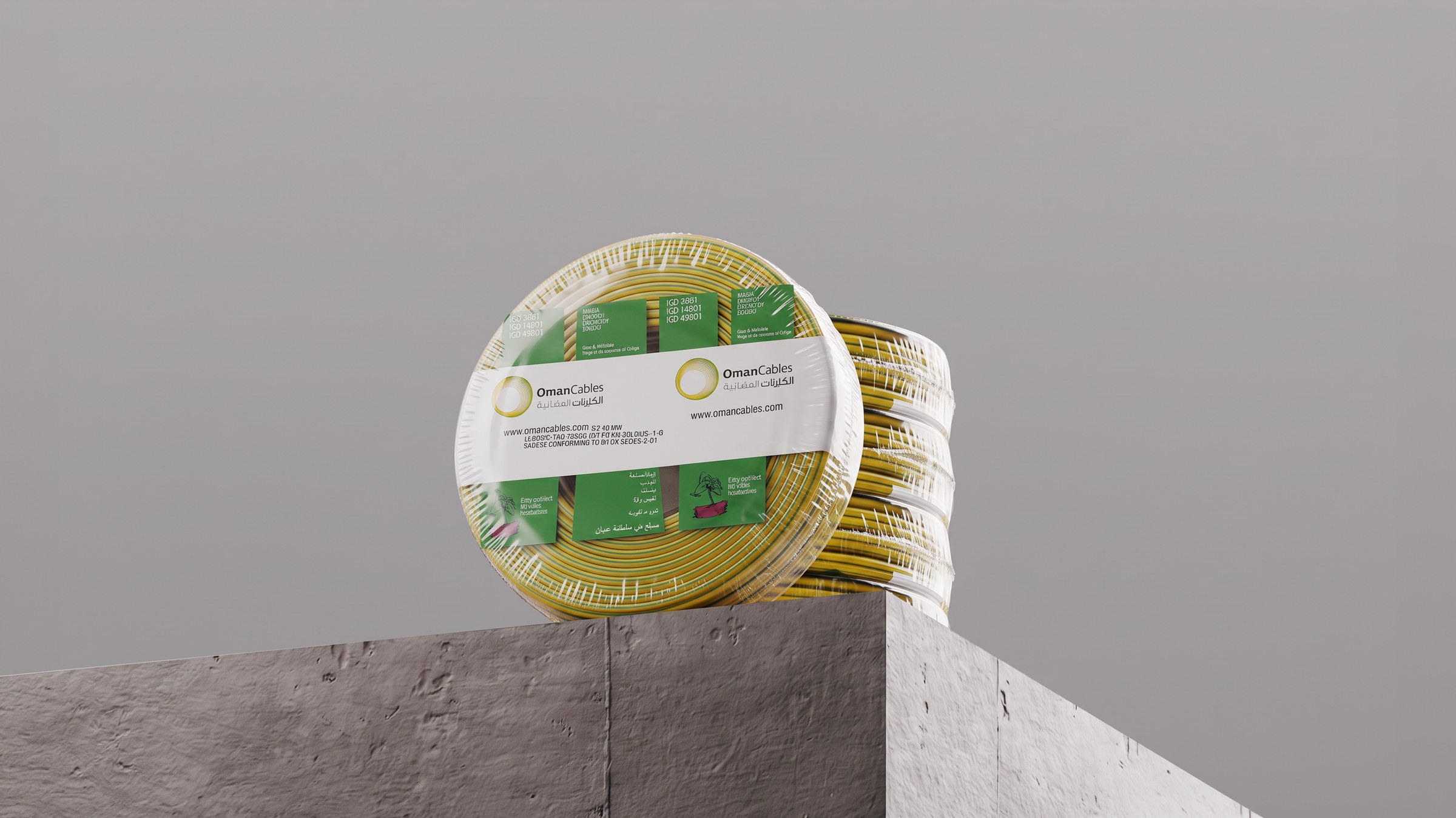 Packed coils of green and yellow Oman Cables on a concrete block